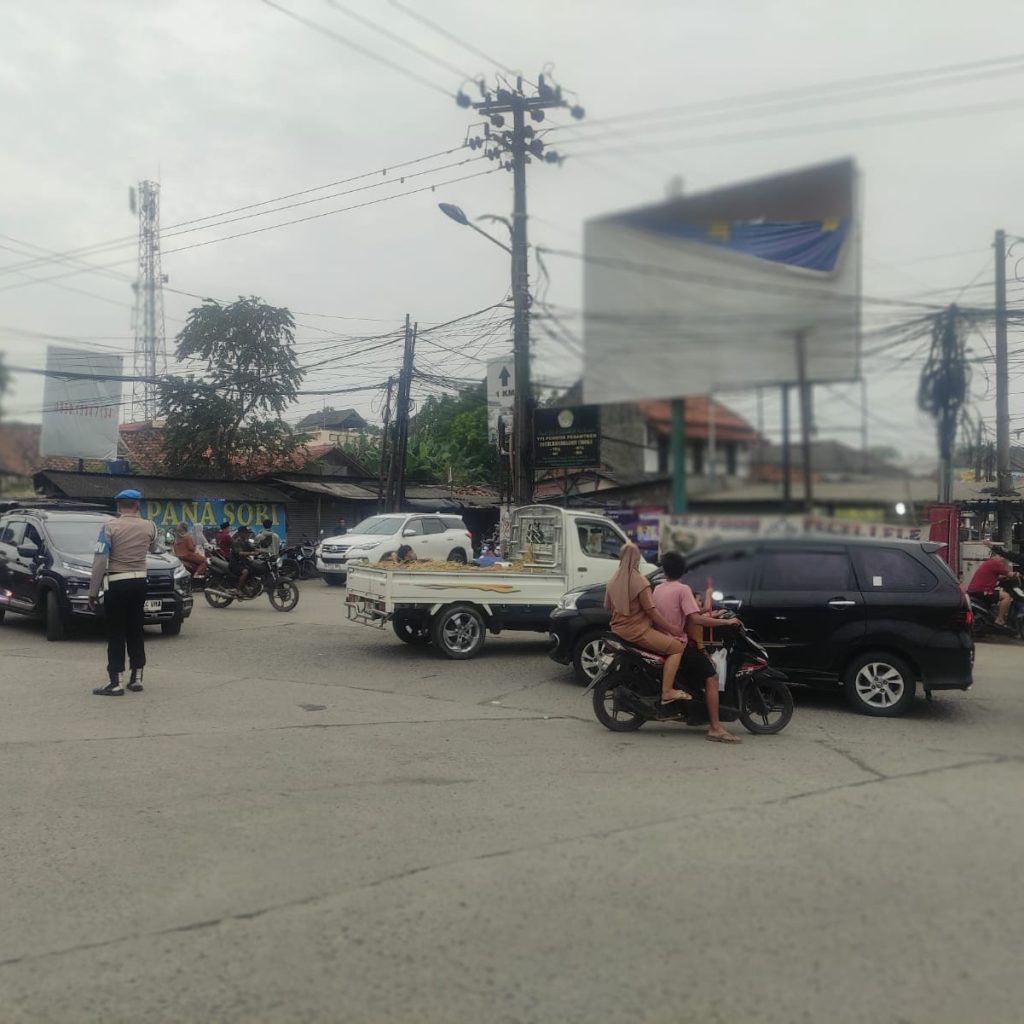 Personil Unit Samapta Polsek Cisoka Polresta Tangerang Polda Banten Bripka Aditya Atur Arus Lalu Lintas Agar tidak Menimbulkan Kemacetan di Simpang jalan raya cisoka
