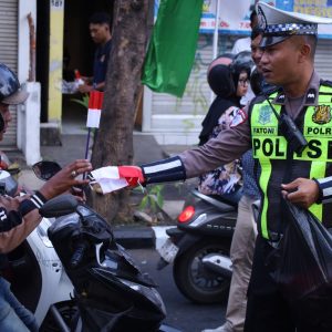 Ratusan Bendera Merah Putih Dibagikan Polres Gresik, Senyum Pengendara Warnai Simpang Empat Sentolang